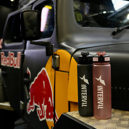Interval water bottles on a car dashboard with Red Bull branding in the background